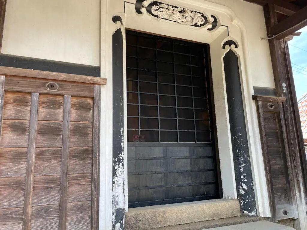 una puerta de madera de garaje en una casa en Kura "Ika" - Vacation STAY 95263v en Nagahama