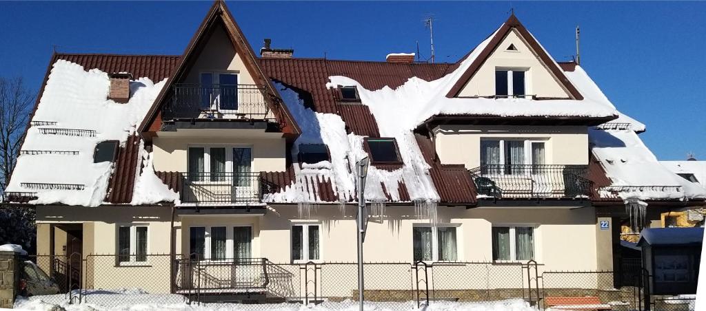 Una casa con nieve al costado. en Willa MIKRUS, en Zakopane