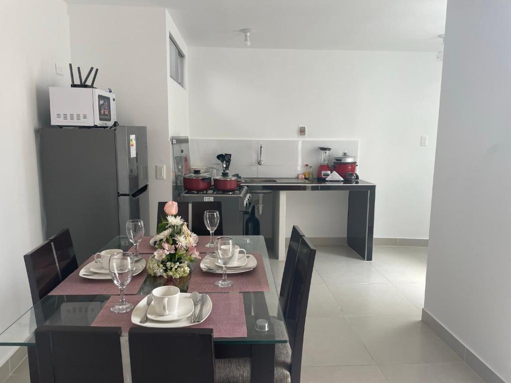 a dining room with a table and chairs and a kitchen at Exclusivo Apartamento en el Centro Histórico Trujillo - 3er Piso in Trujillo