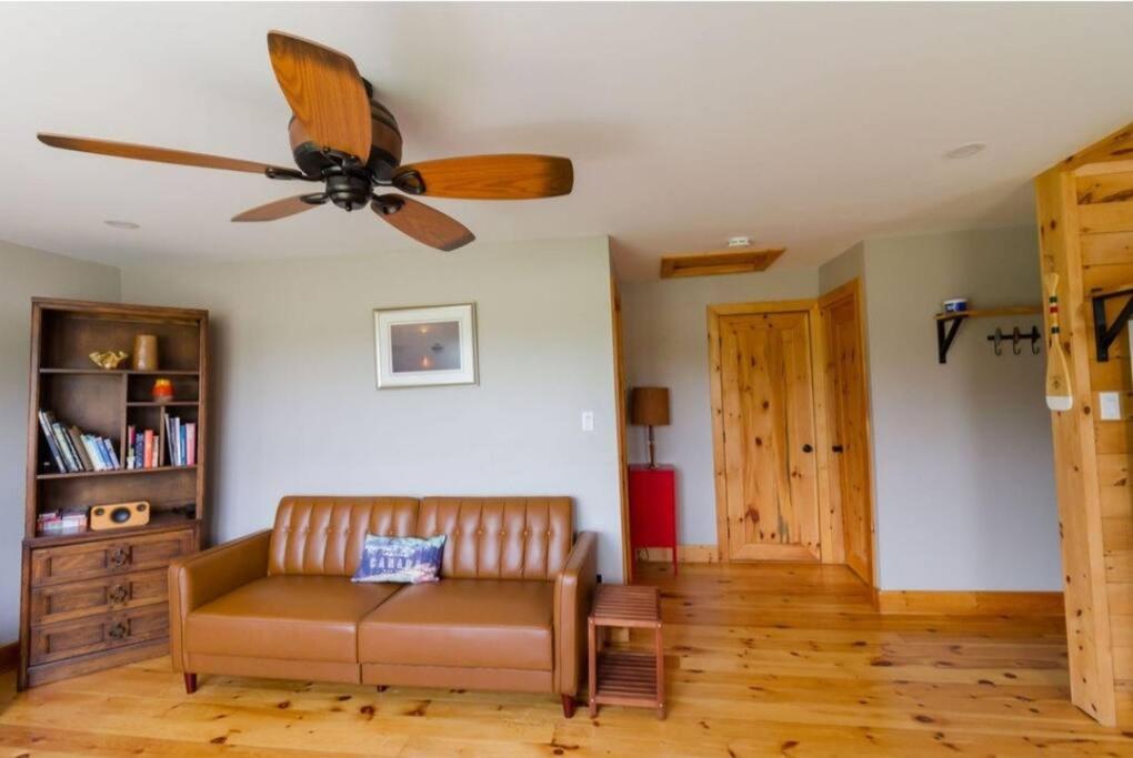 a living room with a couch and a ceiling fan at Steps to Lake on the Mountain - License ST-2020-0324 R1 in Picton