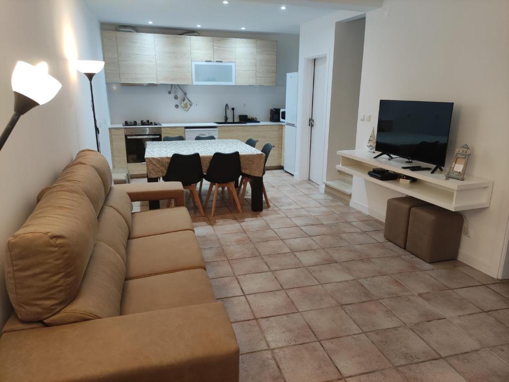 sala de estar con sofá, mesa y cocina en Costa House, en Nazaré