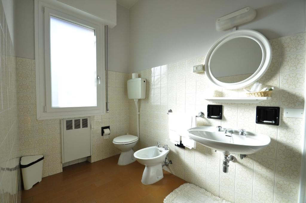 łazienka z umywalką, toaletą i lustrem w obiekcie Albergo "da Mario" w mieście Pianoro