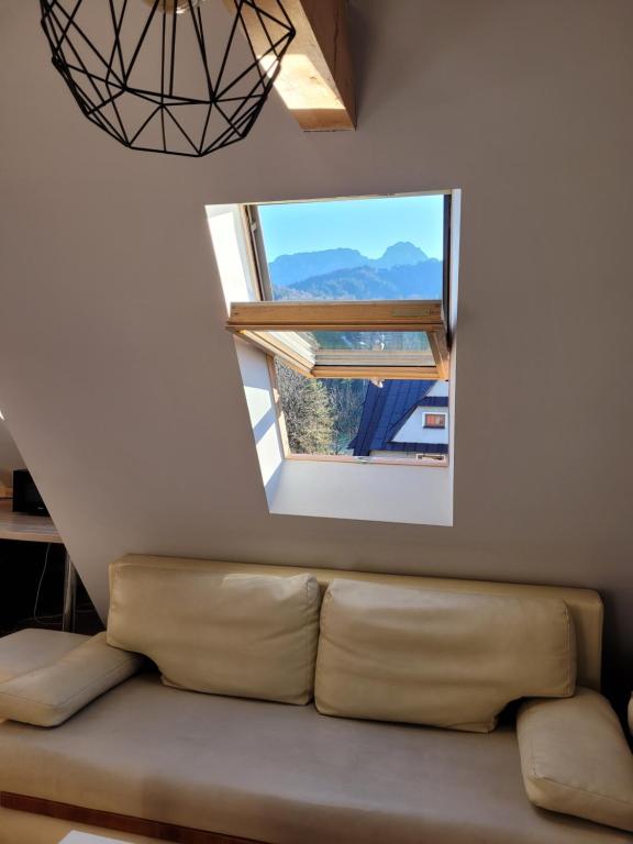 ein Wohnzimmer mit einem Sofa und einem Fenster in der Unterkunft Willa Strumyk in Zakopane
