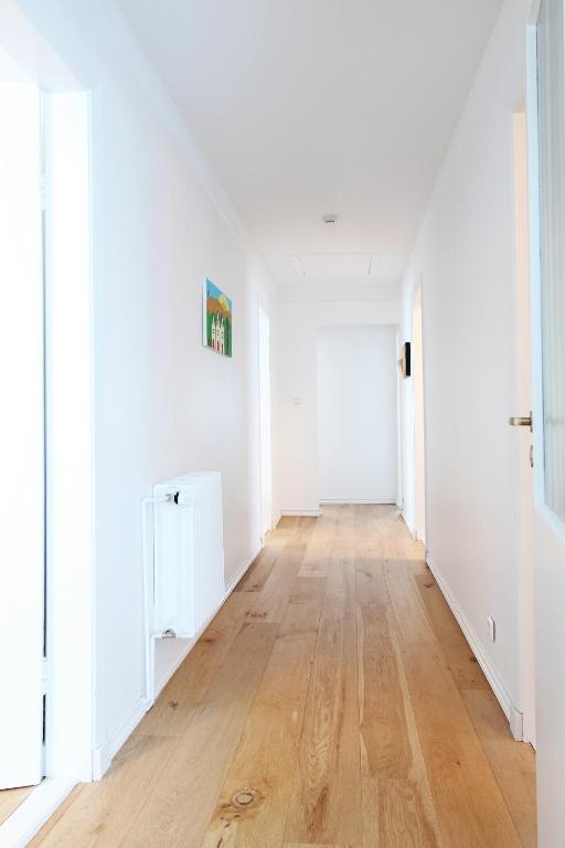 an empty hallway with white walls and wood floors at Mengi Countryside in Kjarnholt