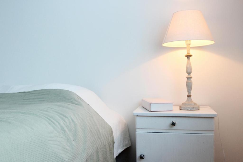 a lamp on a night stand next to a bed at Mengi Countryside in Kjarnholt