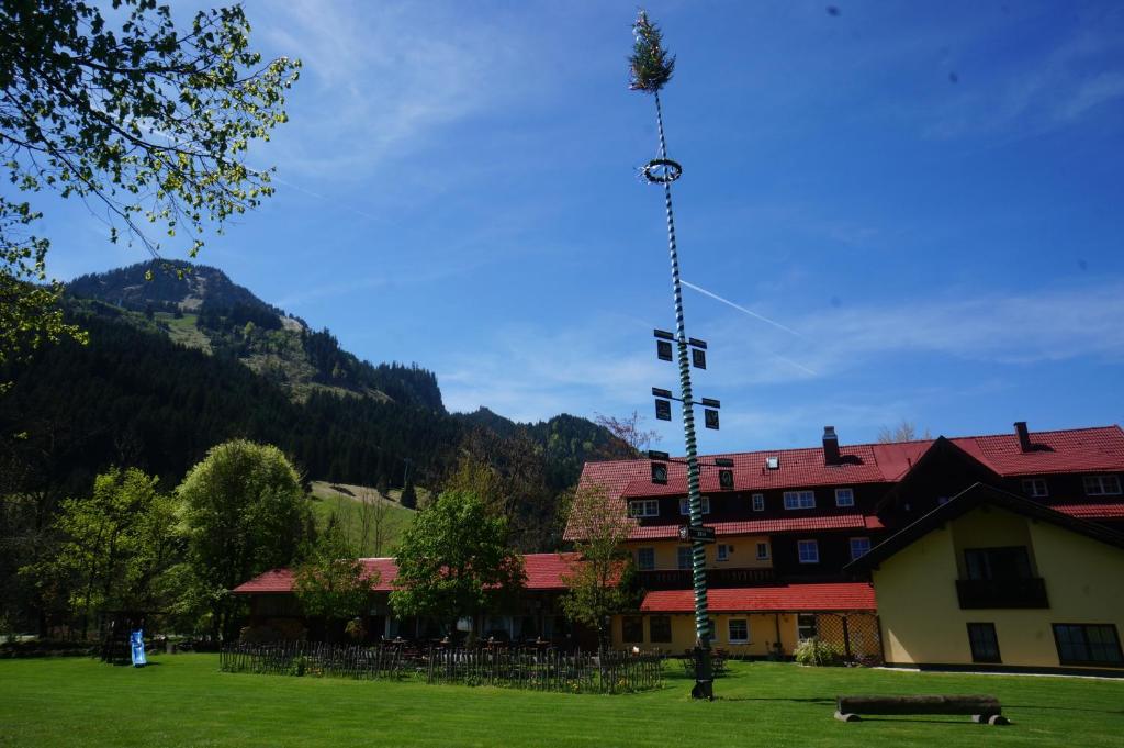 a building with a tower in the middle of a field at Hotel-Gasthof Im Wiesengrund in Bad Hindelang