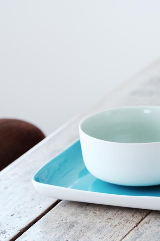 a white bowl on a plate on a table at Mengi Countryside in Kjarnholt