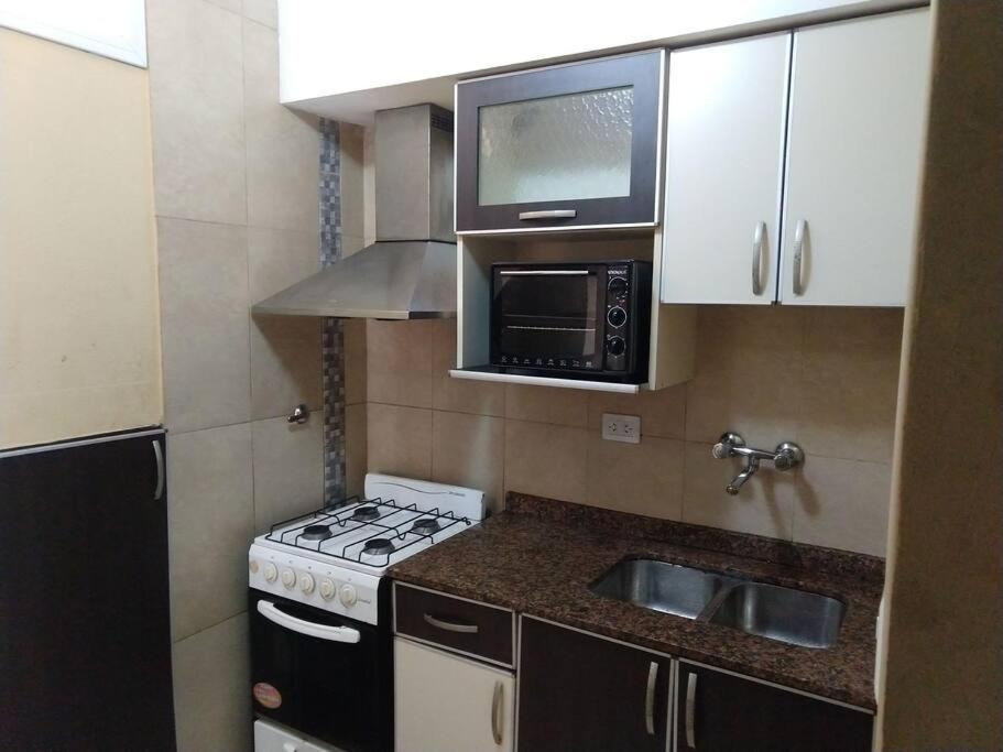 cocina pequeña con fogones y microondas en Departamento 4 en Puerto Iguazú