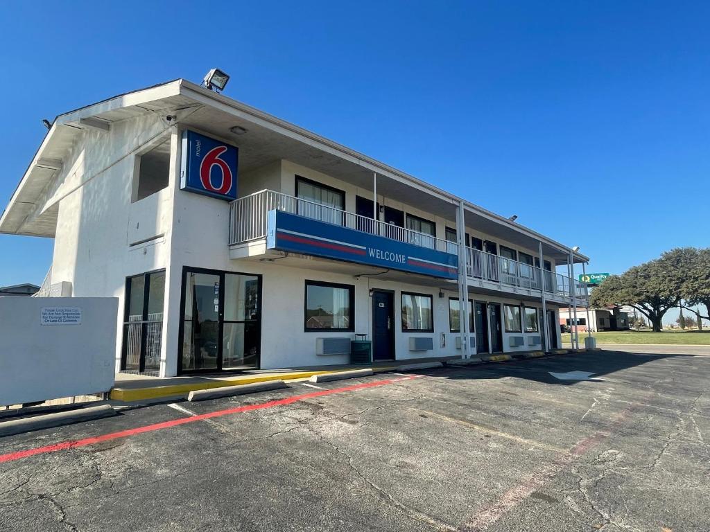 ein großes weißes Gebäude mit einem Schild drauf in der Unterkunft Motel 6 Denton, TX - UNT in Denton