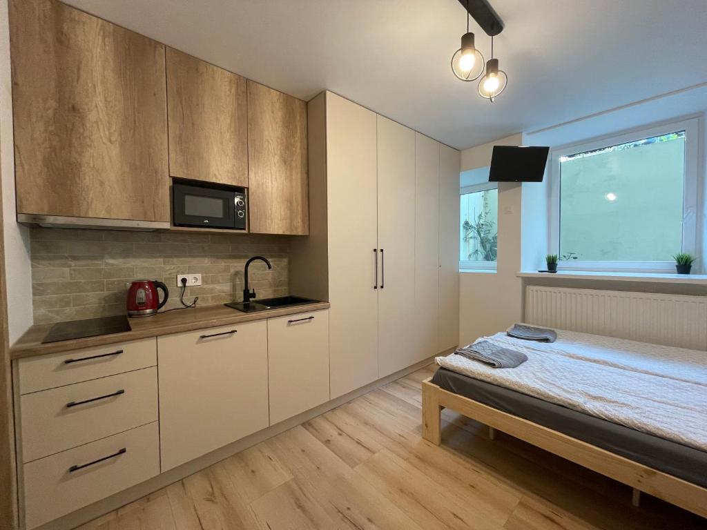 a kitchen with white cabinets and a bed in a room at Modern guest house in city center I Room 3 in Vilnius