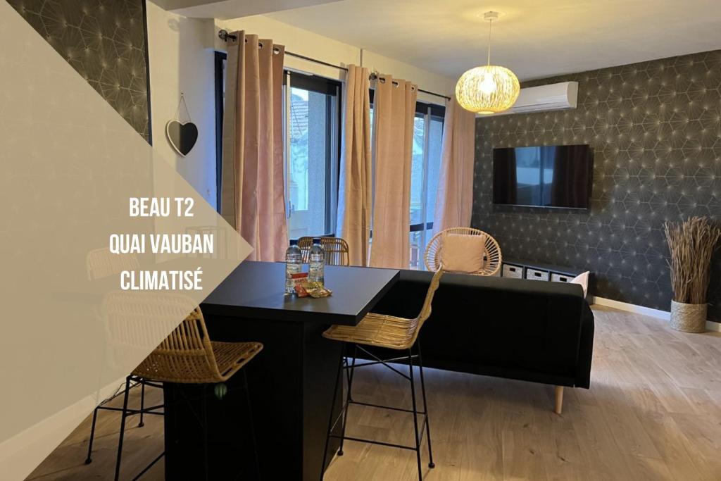Perpignan Vauban magnifique T2 avec balcon في بيربينيا: مطبخ وغرفة طعام مع منضدة سوداء وكراسي