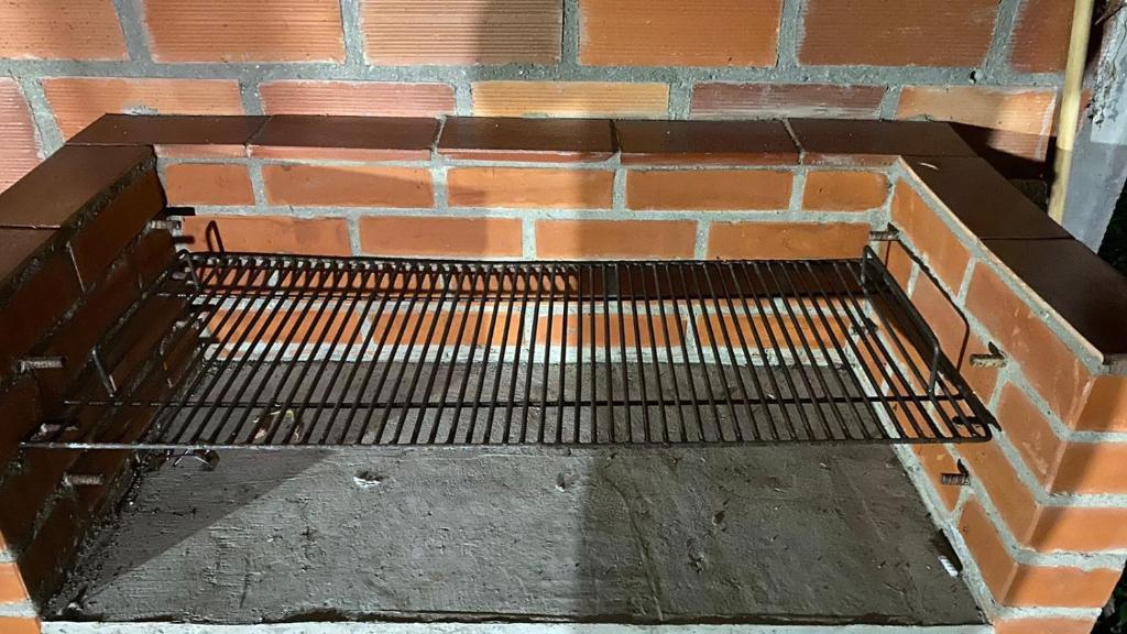 a metal bench sitting next to a brick wall at Finca el Paraíso in San Gil