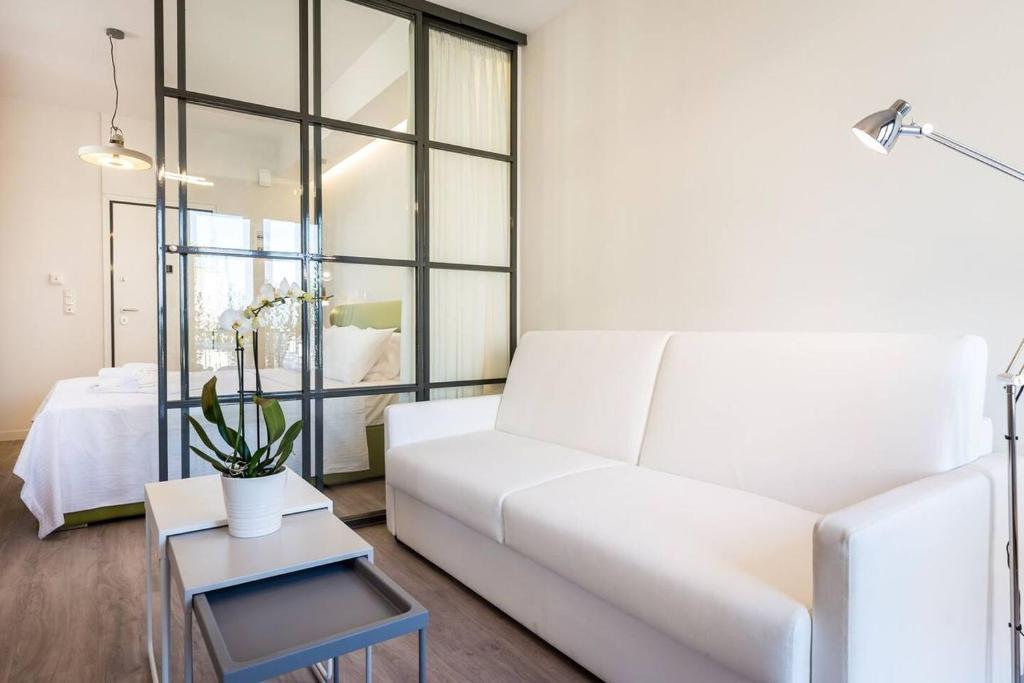 sala de estar con sofá blanco y mesa en Central chic flat with terrace btw Syntagma & Monastiraki en Athens