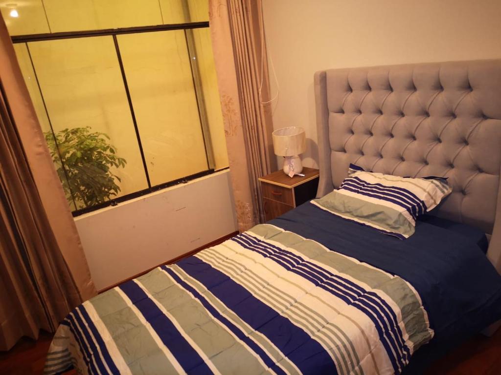 1 dormitorio con cama y ventana en Miski Wasi, en Puno