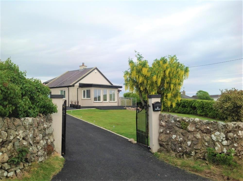 a gate to a house with a stone wall at Firpoint in Rockcliffe