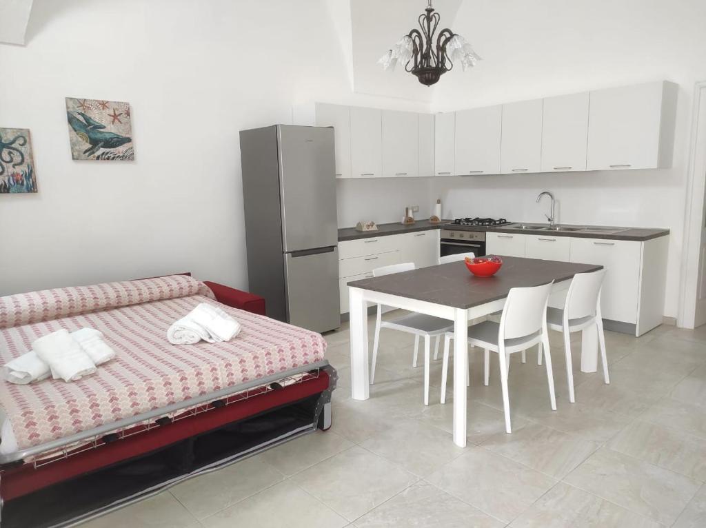 een keuken met een bed en een tafel met stoelen bij Casa Cesira in Casamassella