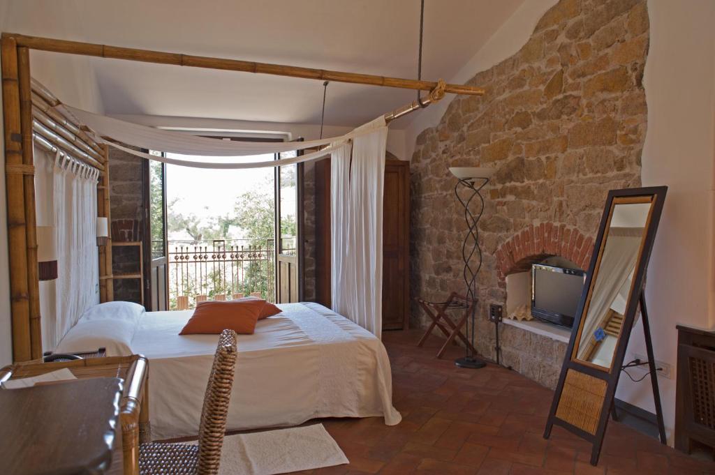 a bedroom with a bed and a stone wall at Nascar Hotel in Santa Maria Navarrese