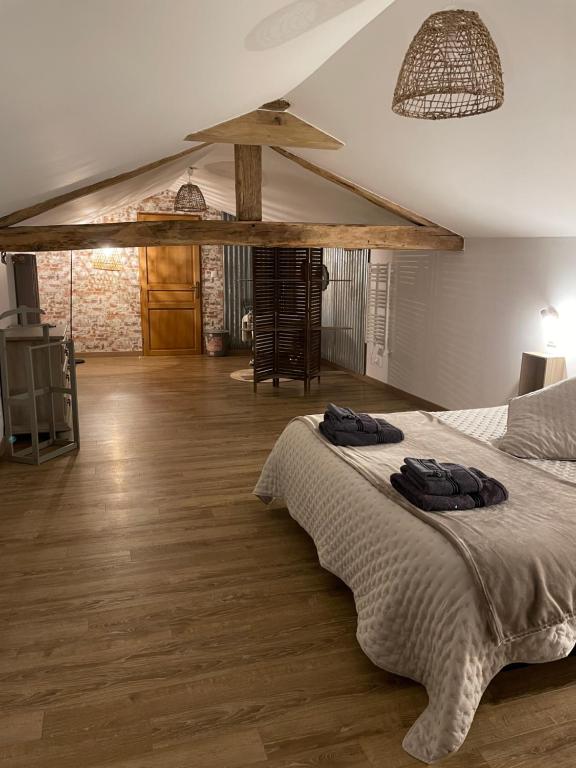 Schlafzimmer mit einem Bett und Holzboden in der Unterkunft Chez Iréne in Villiers-aux-Chênes