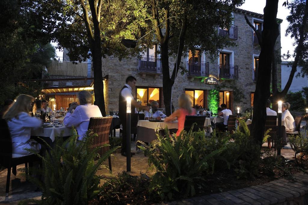 a group of people sitting at tables at a restaurant at Nascar Hotel in Santa Maria Navarrese