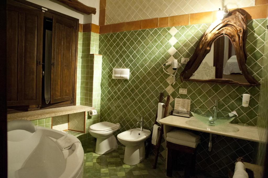 a bathroom with a toilet and a sink and a tub at Nascar Hotel in Santa Maria Navarrese