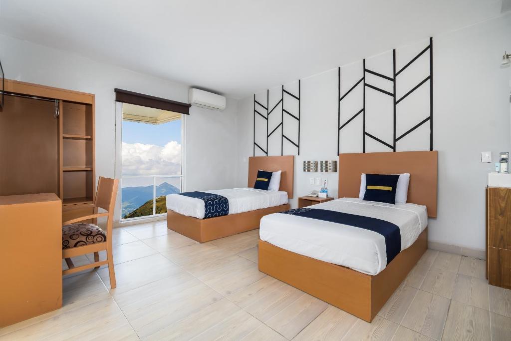 1 dormitorio con 2 camas y ventana grande en Hotel Plaza Regina Torreon en Torreón