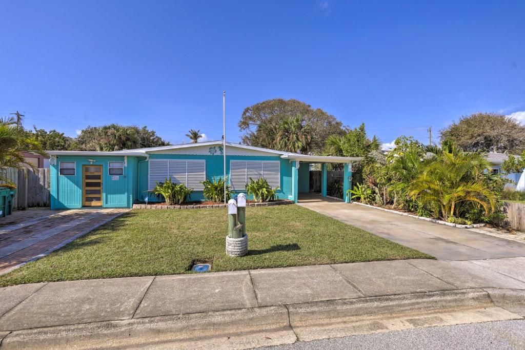 a blue house with a lawn in front of it at Cute and Cozy Florida Duplex Walk to Beaches! in Cocoa Beach