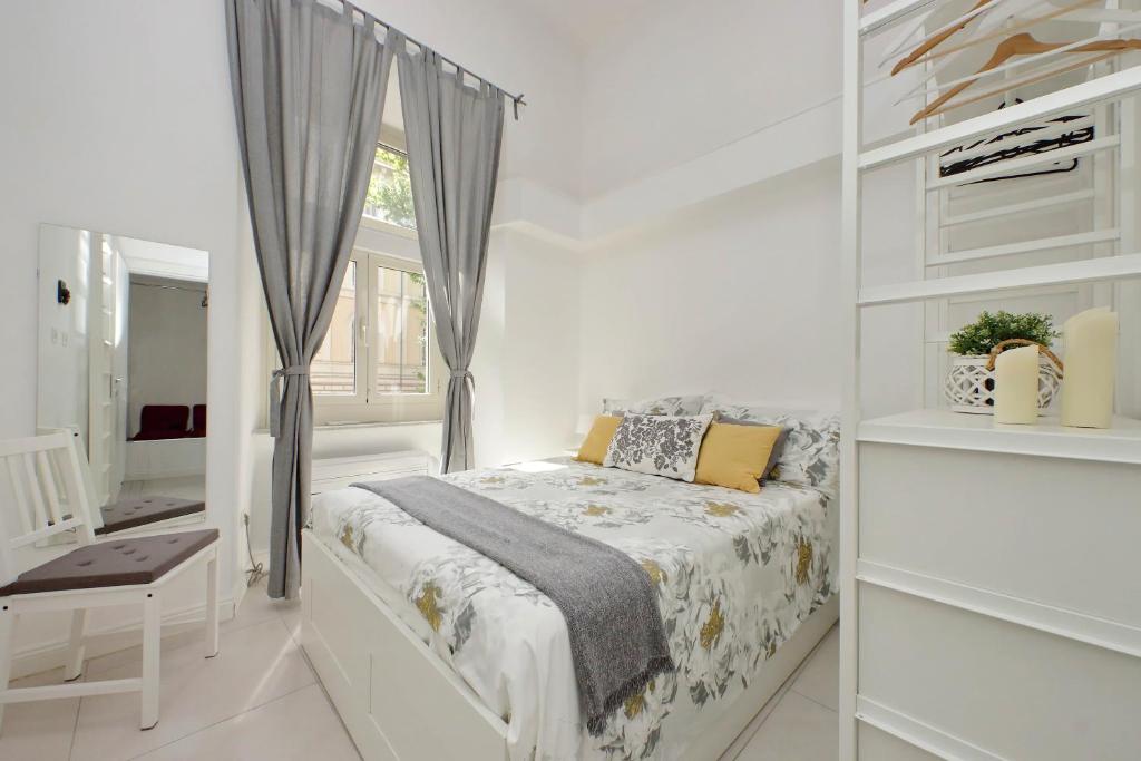 a white bedroom with a bed and a window at CASTRO PRETORIO SUITE - 1 bedroom flat, 2nd floor with lift, comfortable, quite, central, 2 steps from Termini Railway Station and metro A and B lines, a walk from Colosseum, Trevi Fountain, Spanish Steps, free welcome drinks in Rome