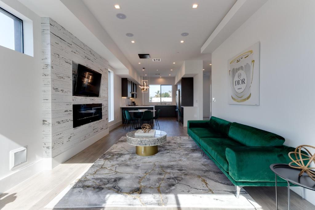- un salon avec un canapé vert et une table dans l'établissement Modern 5 Bedroom Masterpiece With Rooftop Deck, à Los Angeles