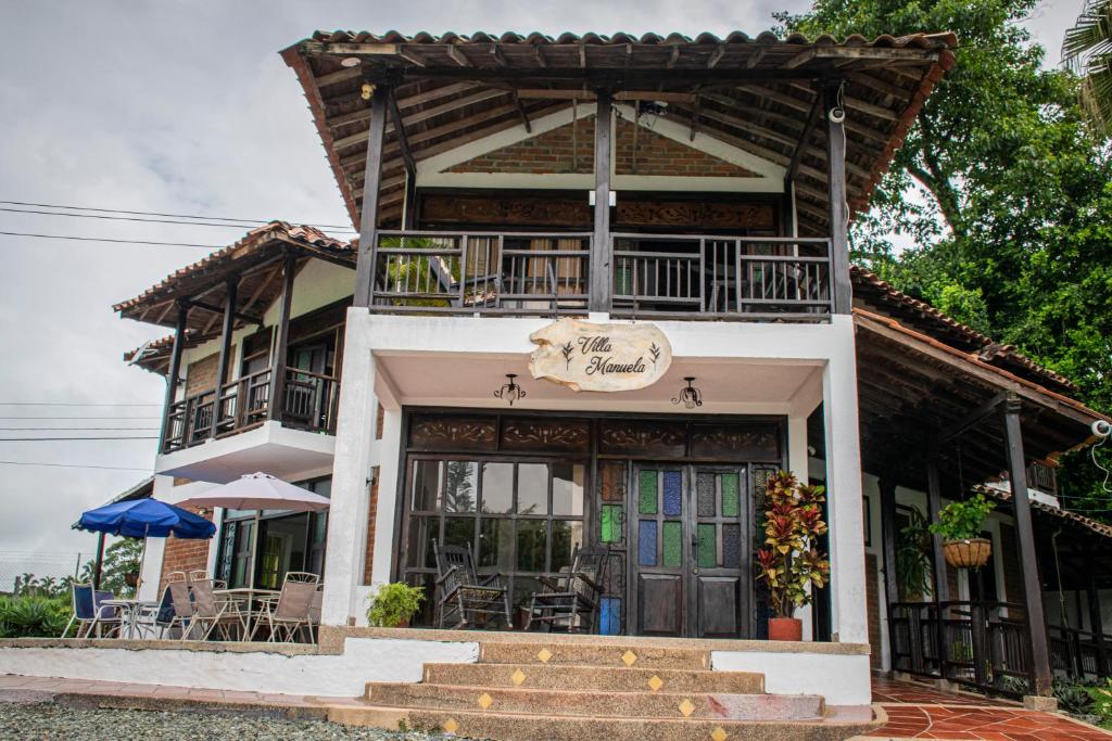 uma casa com um alpendre e escadas em frente em Finca Hotel Casa Nostra, Villa Manuela em Quimbaya