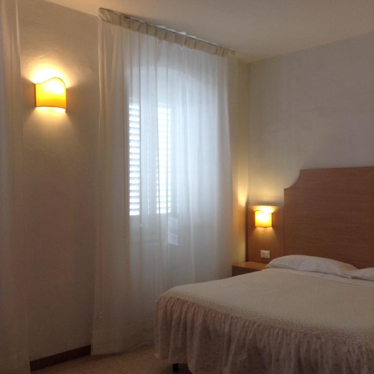 Postel nebo postele na pokoji v ubytování Albergo Giugni