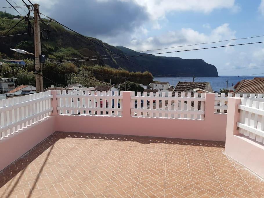 a white fence with a view of the water at Casa da Ribeira - Mosteiros in Mosteiros
