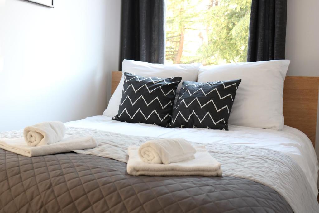 a bed with towels on it with a window at DMK Green Apartment near Warsaw-Modlin Airport in Nowy Dwór Mazowiecki