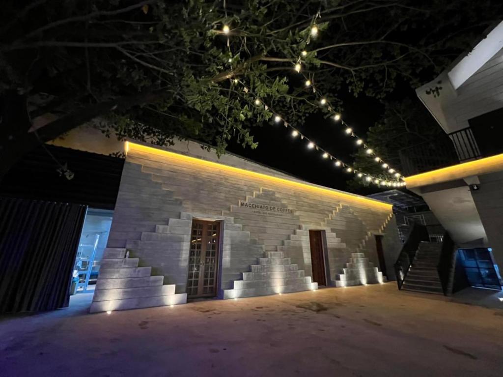 a brick building with lights on it at night at Macchiato Resort Savannakhet Opposite Thai Embassy in Savannakhet