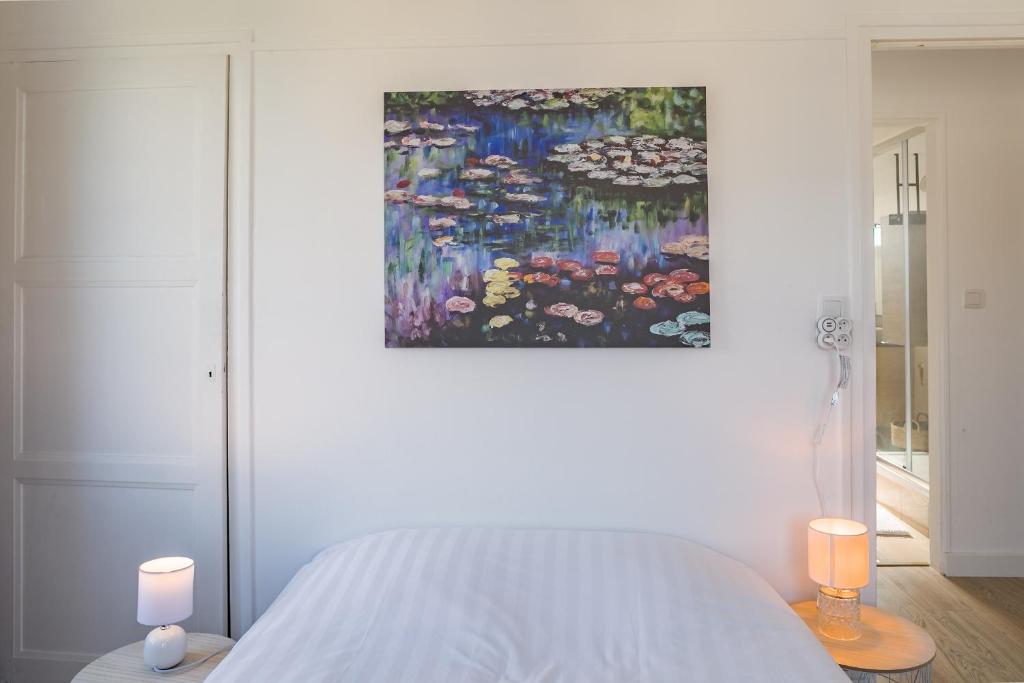 a bedroom with a bed and a painting on the wall at Le May Flower - 3 Chambres - Proche Centre-Ville in Troyes