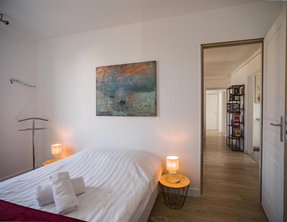 a bedroom with a white bed and a painting on the wall at Le May Flower - 3 Chambres - Proche Centre-Ville in Troyes