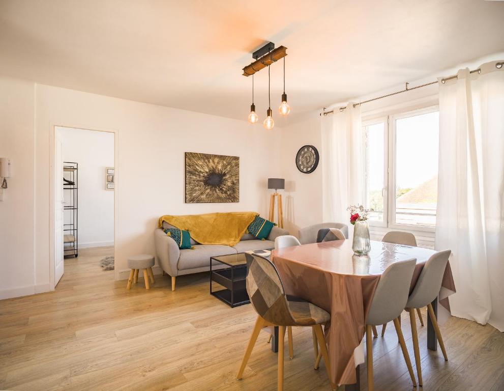 a living room with a table and a couch at Le May Flower - 3 Chambres - Proche Centre-Ville in Troyes