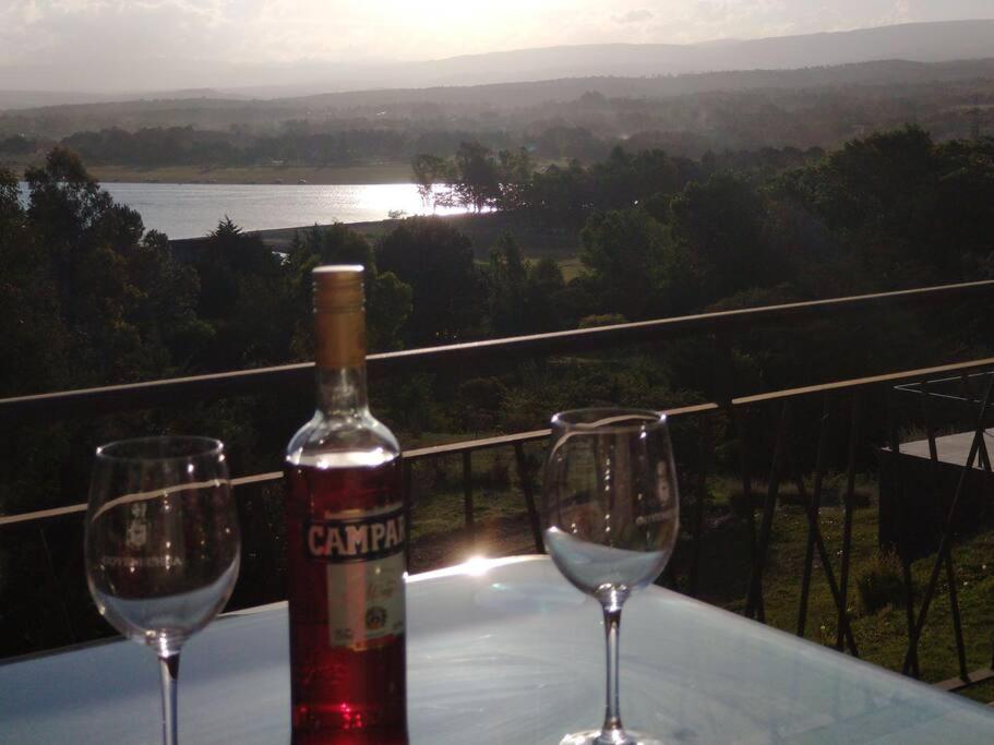 a bottle of wine and two wine glasses on a table at Condominio Monte Molinos - Departamento en Náutico frente al Lago in Villa Ciudad de América