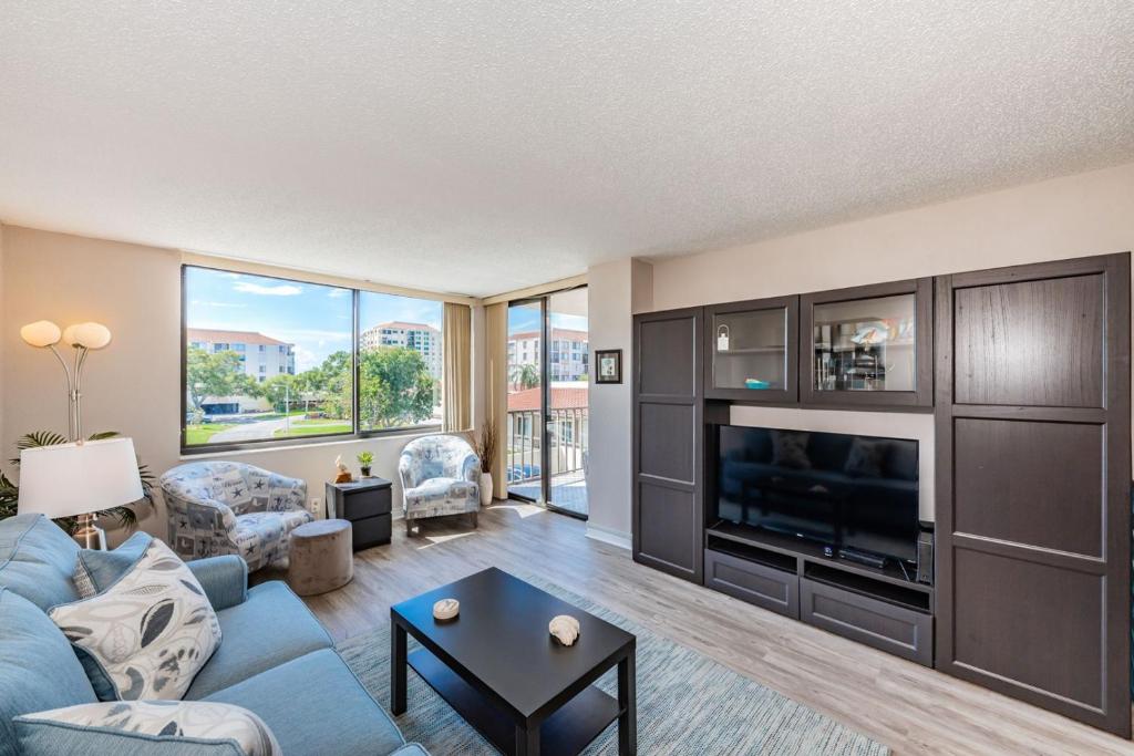a living room with a blue couch and a tv at Palma Fabulous Island View Condo in St Petersburg