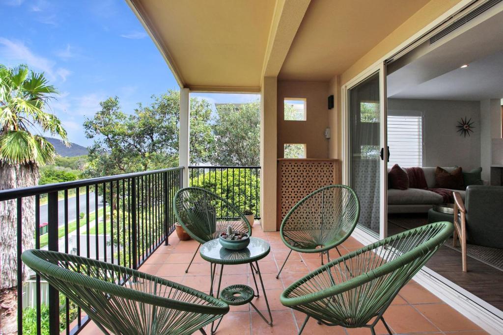 eine Veranda mit Stühlen und einem Tisch auf dem Balkon in der Unterkunft Aquarius Apartment 9 in Hawks Nest