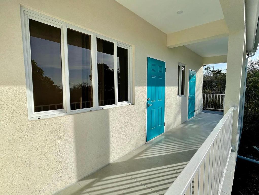 une maison avec des portes bleues et une terrasse couverte dans l'établissement Hilltop Condos, à Gros Islet