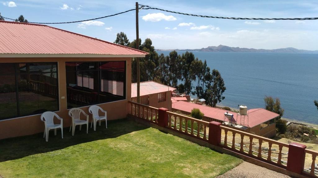 uma casa com uma varanda com vista para a água em Paqariy lodge em Ocosuyo