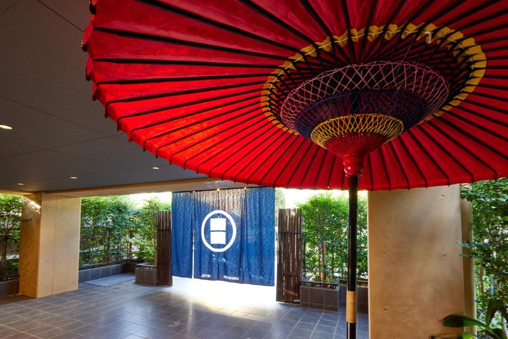 einem roten Regenschirm, der von der Decke eines Gebäudes hängt in der Unterkunft KAMAKURA Hotel in Kamakura