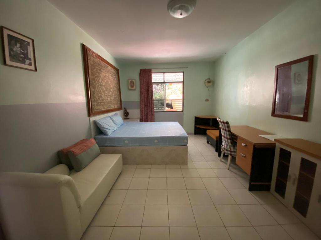 um quarto com uma cama, um sofá e uma secretária em Nan Inn Bungalow em Praia de Karon