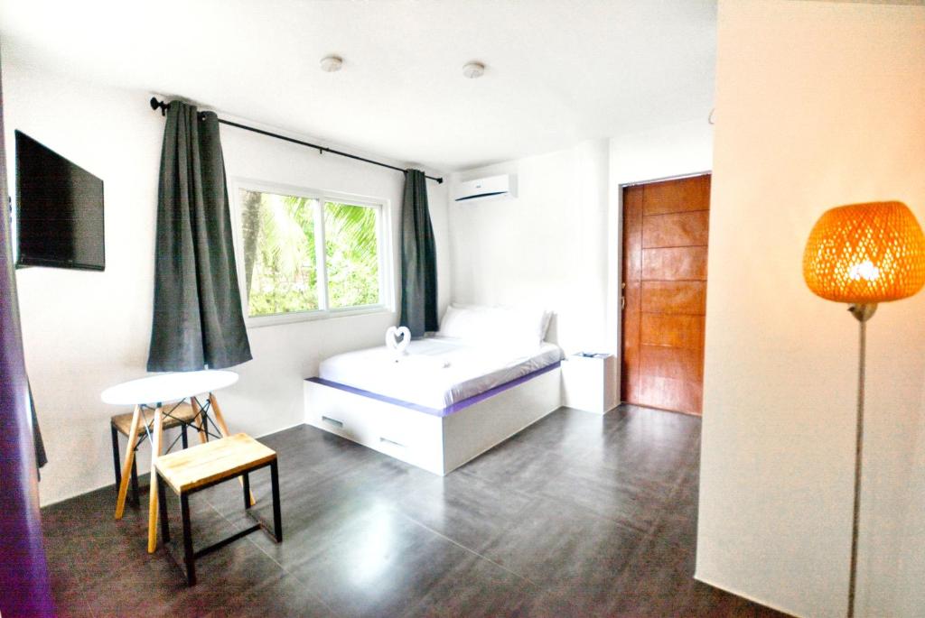 a bedroom with a white bed and a window at BABOSAM Hotel in Boracay