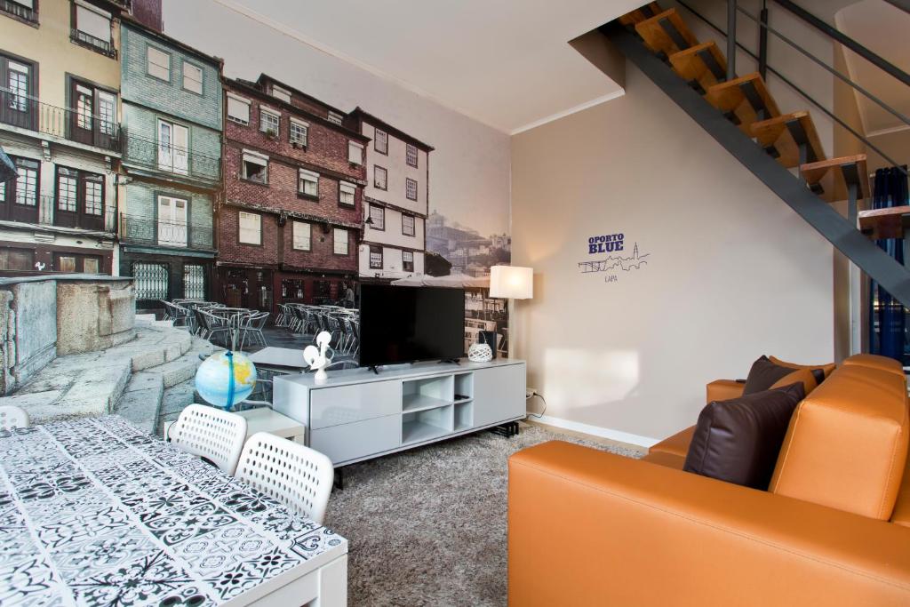 sala de estar con sofá y mesa con TV en Oporto Blue Lapa - Original Citycenter House! en Oporto