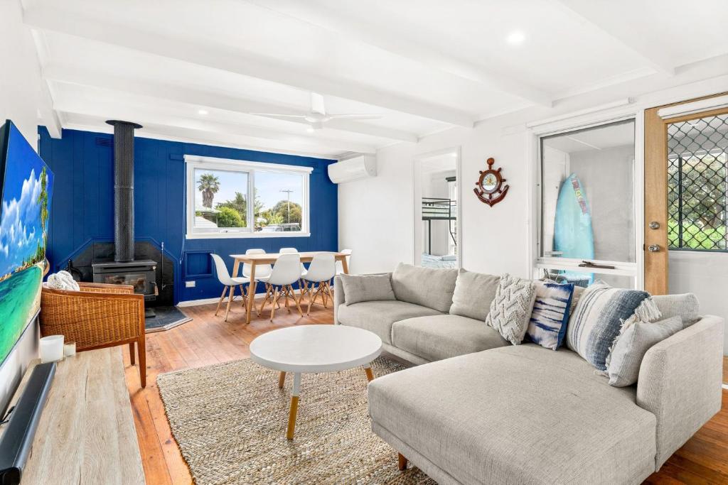 a living room with a couch and a table at Cape Surf House in Cape Woolamai