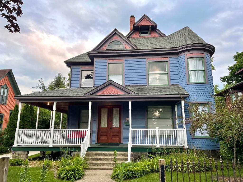 een blauw huis met een rode deur bij Art and Lodging in South Bend