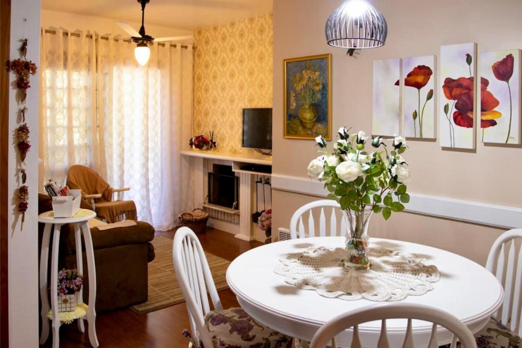 een woonkamer met een tafel met een vaas met bloemen erop bij Encanto pertinho do Mini Mundo in Gramado