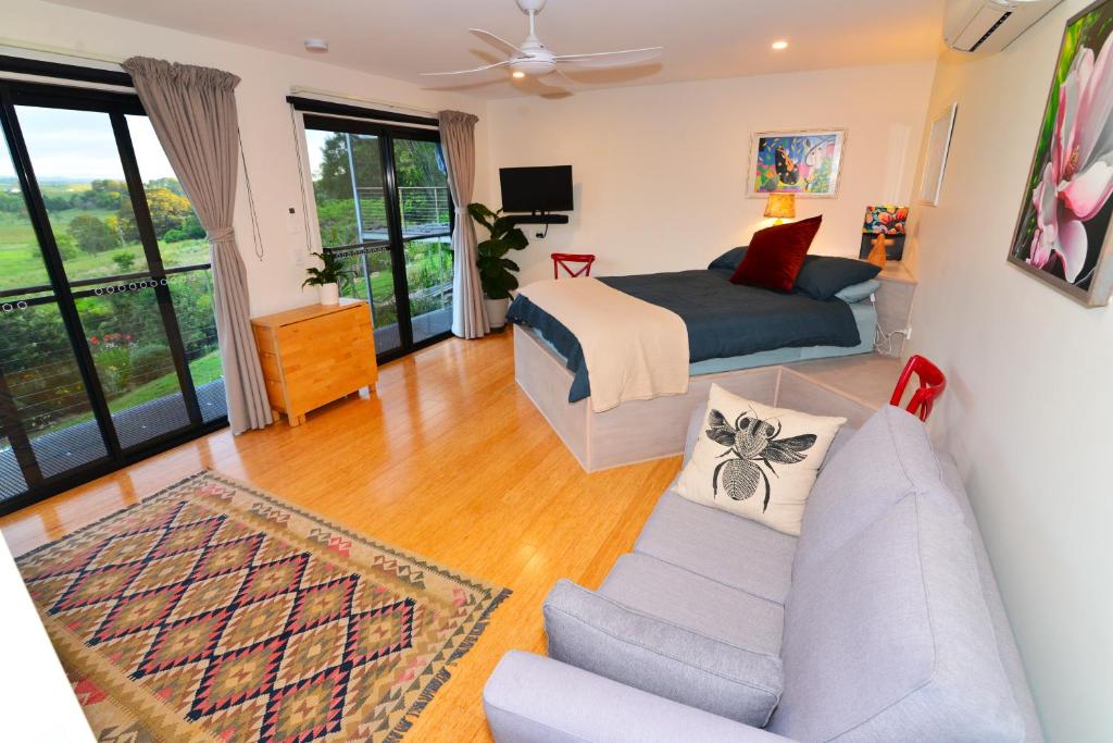 a living room with a bed and a couch at Studio with Rural views in Goonellabah