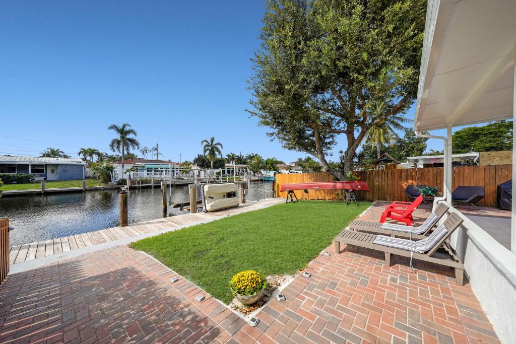 une terrasse avec deux chaises et une pelouse avec un bateau dans l'établissement Dania Beach Waterfront,near Hollywood & Fll, à Dania Beach